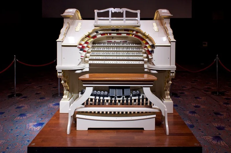 An ornate Wurlitzer theatre organ console with rows of stop tabs, multiple keyboards, and a pedalboard
