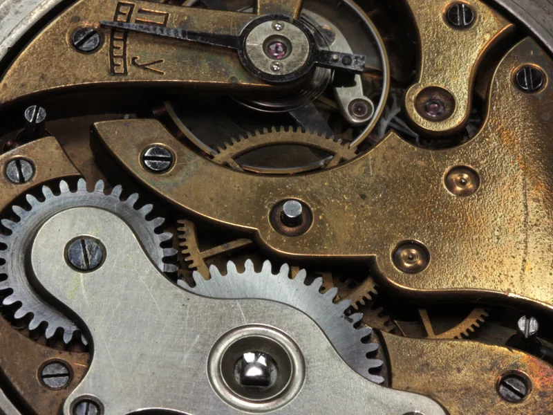 An intricate mechanical clockwork movement with many interlocking brass gears